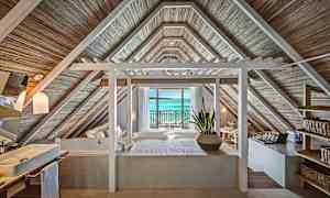 Huone, jossa on puupaneelikatto ja näkymä merelle lasiovien kautta. (Tekoälyn luoma teksti)