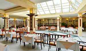 Tilava ravintola, jossa on suuret ikkunat ja pöydät valkoisilla liinoilla. (Tekoälyn luoma teksti)