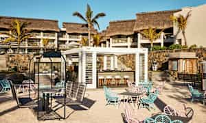 Ulkobaari, jossa istumapaikkoja hiekkarannalla hotellin edessä. (Tekoälyn luoma teksti)