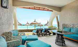 Terassi, jossa sinisiä istuimia ja näkymä merelle aurinkovarjojen kanssa. (Tekoälyn luoma teksti)