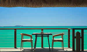 Katettu pöytä ja kaksi tuolia terassilla merinäköalalla. (Tekoälyn luoma teksti)