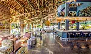 Tilava lounge, jossa puupalkit katossa, istumaryhmät ja baari. (Tekoälyn luoma teksti)