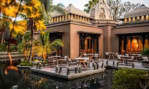 Ulkotila, jossa pöytiä ja tuoleja rakennuksen kupolikattojen vieressä. (Tekoälyn luoma teksti)