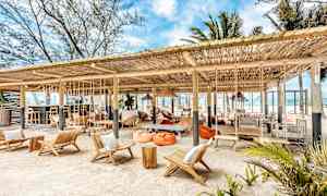 Rantabaari istuinryhmien ja riippumattojen kanssa puukatoksen alla. (Tekoälyn luoma teksti)