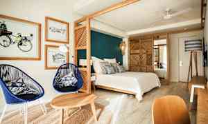 Moderni makuuhuone, jossa on sänky, puukalusteet ja tyylikäs sisustus. (Tekoälyn luoma teksti)