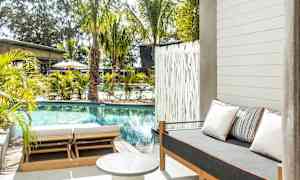 Ulkotila, jossa uima-allas, aurinkotuoleja ja sohva tyynyineen. (Tekoälyn luoma teksti)