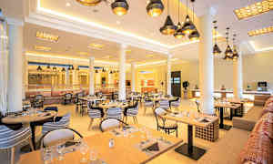 Ravintola katetuilla pöydillä ja riippuvilla kattovaloilla. (Tekoälyn luoma teksti)