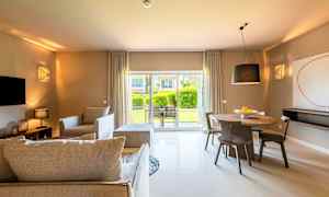 Olohuone, jossa on nykyaikaiset huonekalut ja ruokailutila, suuret ikkunat näyttävät puutarhan ulkopuolella. (Tekoälyn luoma teksti)