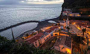 Rannikolla sijaitseva kaupunki rakennuksineen ja pienine rantoineen ilta-aikaan. (Tekoälyn luoma teksti)