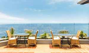 Terassi, jossa on rottinkikalusteet ja näkymä merelle. (Tekoälyn luoma teksti)