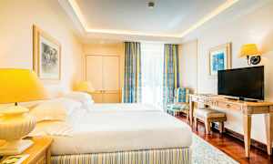 Hotellihuone, jossa on kaksi sänkyä, televisio ja tuoli. (Tekoälyn luoma teksti)