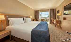 Hotellihuone, jossa on kaksi erillistä vuodetta ja parveke näkymällä. (Tekoälyn luoma teksti)