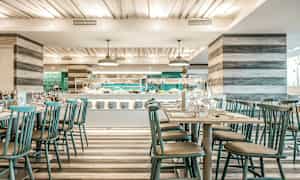 Kuva modernista ravintolasta, jossa on katettuja pöytiä ja buffetti taustalla. (Tekoälyn luoma teksti)