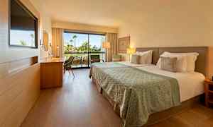 Moderni hotellihuone, jossa parisänky ja taustalla parveke. (Tekoälyn luoma teksti)