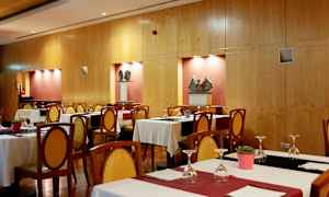 Ravintola, jossa on katettuja pöytiä ja tuoleja sekä taideteoksia seinillä. (Tekoälyn luoma teksti)