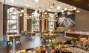 Tyylikäs ravintola, jossa on modernit riippuvalaisimet, katetut pöydät ja suuret ikkunat, joista tulvii luonnonvaloa. (Tekoälyn luoma teksti)