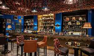 Tyylikäs baarin sisustus, jossa istumapaikkoja ja koristeltu katto. (Tekoälyn luoma teksti)