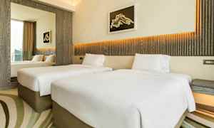 Hotellihuone, jossa on kaksi erillistä vuodetta, moderni sisustus ja vaaleat värit. (Tekoälyn luoma teksti)