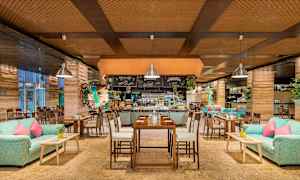 Ravintola, jossa on puusisustus, sohvia, pöytiä ja koristeita. (Tekoälyn luoma teksti)