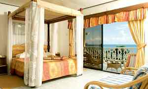 Makuuhuone, jossa on pylvässänky ja näkymä merelle parvekkeelta. (Tekoälyn luoma teksti)