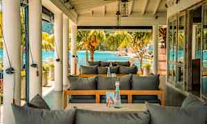 Ulkoterassi, josta on näkymät merelle, harmaat pehmustetut istuimet. (Tekoälyn luoma teksti)