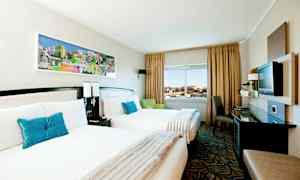 Hotellihuone, jossa kaksi yhden hengen sänkyä, ikkunanäkymä ja nykyaikainen sisustus. (Tekoälyn luoma teksti)