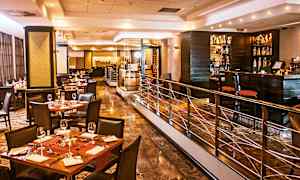 Tyylikäs ravintola, jossa on katetut pöydät, tuolit ja baaritiski. (Tekoälyn luoma teksti)