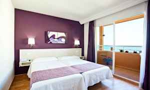 Huone, jossa parivuode, violetti seinä ja parveke merinäköalalla. (Tekoälyn luoma teksti)