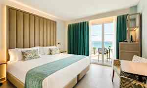 Hotellihuone, jossa suuri sänky ja parveke merinäköalalla. (Tekoälyn luoma teksti)