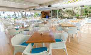 Ulkoterassi ravintola pöytineen ja tuoleineen panoraamaikkunoiden edessä. (Tekoälyn luoma teksti)