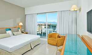 Hotellihuone, jossa on parivuode, nojatuoli ja lasipöytä. (Tekoälyn luoma teksti)