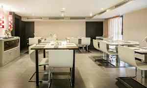 Kuva modernista ja tyylikkäästä ruokasalista, jossa on valkoiset tuolit ja tummat pöydät. (Tekoälyn luoma teksti)