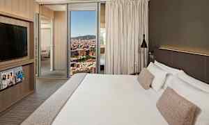 Hotellihuone, jossa on suuri sänky, valkoiset vuodevaatteet ja beiget tyynyt, moderni muotoilu, TV-kaappi, aikakauslehtiä ja ikkuna, josta näkyy kaupunkinäkymä. (Tekoälyn luoma teksti)