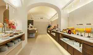 Buffet, jossa ruokaa ja juomia hyvin valaistussa tilassa, jossa on kaarikatto. (Tekoälyn luoma teksti)