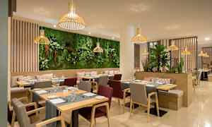 Moderni ravintola, jossa on puukalusteita ja vihreitä kasveja koristeena. (Tekoälyn luoma teksti)
