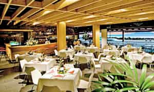 Ravintolan sisustus, jossa on katettuja pöytiä ja koristeellisia kukkia. (Tekoälyn luoma teksti)