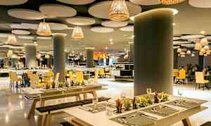 Tyylikäs ravintola, jossa on moderni sisustus, penkit ja pöydät koristeltu pienillä kasveilla. (Tekoälyn luoma teksti)