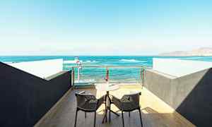 Terassi, jossa on kaksi tuolia ja pöytä merinäköalalla. (Tekoälyn luoma teksti)