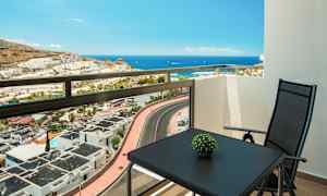 Näkymä parvekkeelta merelle, pöytä ja tuoli näkyvissä. (Tekoälyn luoma teksti)