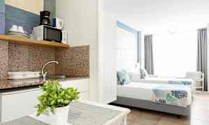 Hotellihuoneen sisustus, jossa on keittokomero ja kaksi yhden hengen vuodetta. (Tekoälyn luoma teksti)