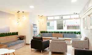 Modernisti sisustettu odotushuone, jossa on sohvia, tuoleja ja koristevalaisimia. (Tekoälyn luoma teksti)