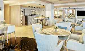 Modernin kahvilan sisustus, jossa on vaaleat kalusteet ja baaritiski. (Tekoälyn luoma teksti)