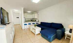 Olohuone, jossa tummansininen sohva ja avoin keittiö. (Tekoälyn luoma teksti)