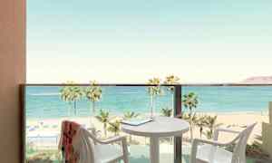 Parveke, josta näkymä rannalle ja merelle, pöytä ja tuolit näkyvissä. (Tekoälyn luoma teksti)