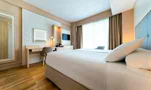 Hotellihuone, jossa on sänky, työpöytä ja ikkuna. (Tekoälyn luoma teksti)