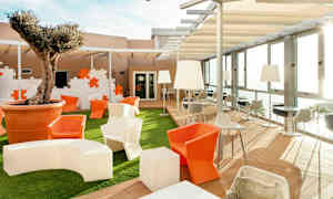 Ulkotila, jossa istuinalueita, pöytiä ja suuri ruukkuun istutettu puu. (Tekoälyn luoma teksti)