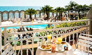 Näkymä parvekkeelta, jossa aamiainen katettuna, uima-allasalueelle ja merelle. (Tekoälyn luoma teksti)