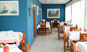 Ravintola, jossa on puisia pöytiä ja tuoleja, siniset seinät sekä koristeita ja tauluja. (Tekoälyn luoma teksti)