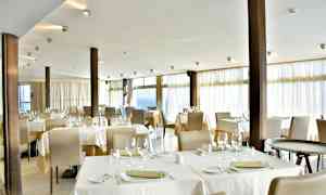 Kuva ravintolasta, jossa pöydät ovat katettuina ja tuolit paikallaan. (Tekoälyn luoma teksti)