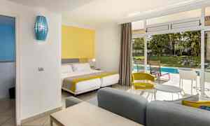 Hotellihuone, jossa on värikäs sisustus ja näkymä puutarhaan ja uima-altaalle. (Tekoälyn luoma teksti)